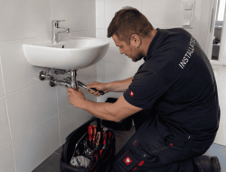 Installateur in Wien bei Sanitararbeiten unter Waschbecken im Badezimmer